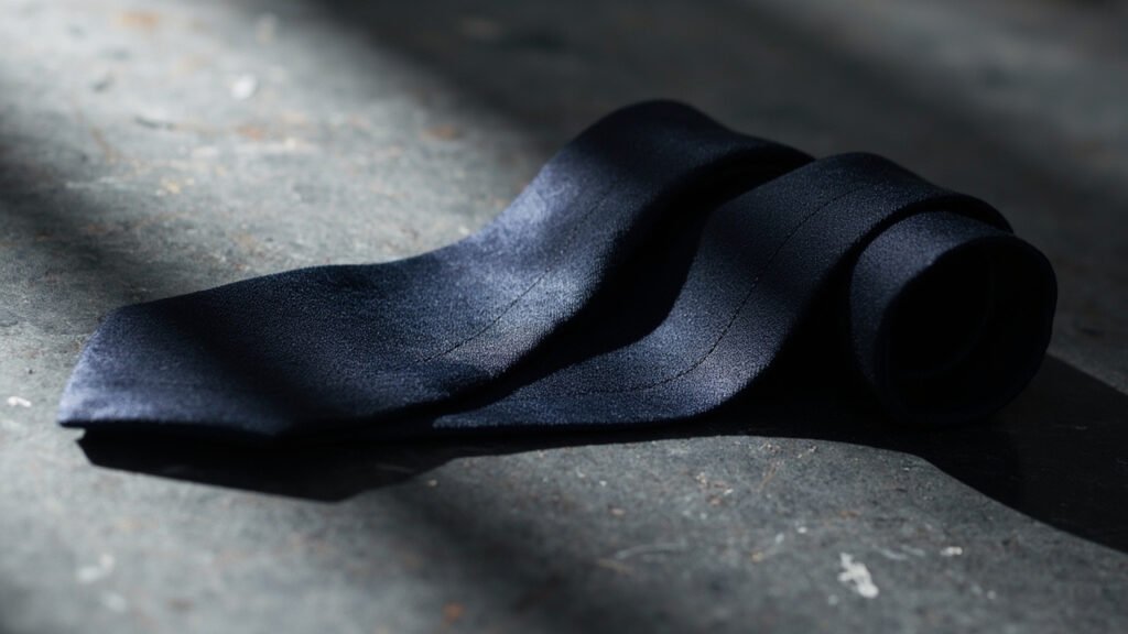 Cravate en soie marine, armure twill et lueur soyeuse.