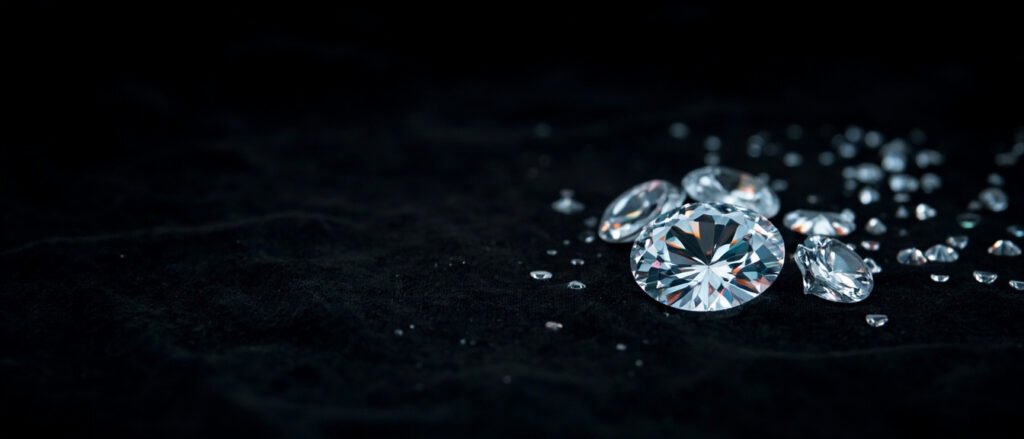 Diamants taille brillant sur velours noir, reflets prismatiques, composition panoramique épurée.
