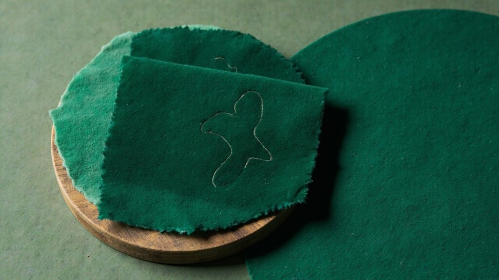 Disque de bois tendu de velours vert, trace d'abrasion en huit.