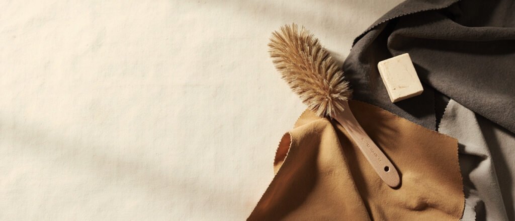 Échantillons nubuck et daim taupe et charbon, lumière douce sur lin crème.
