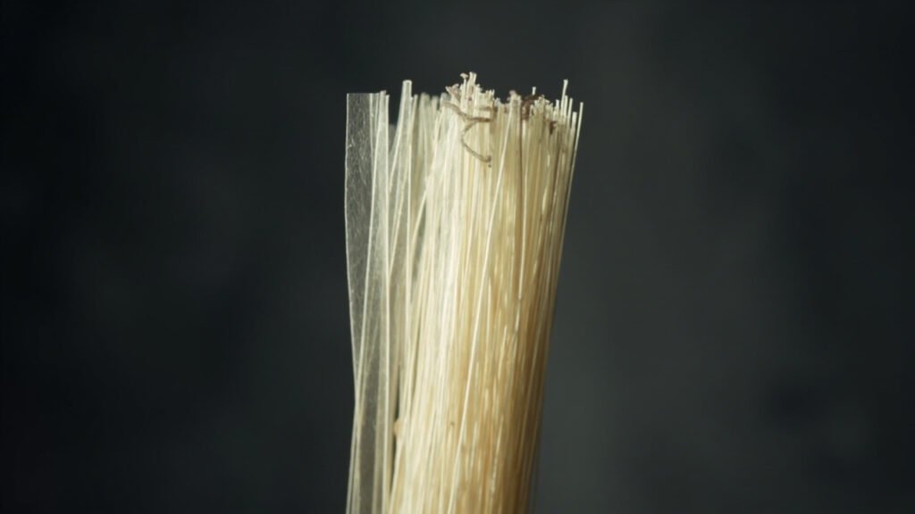 Faisceau de filaments de soie brute formant un prisme translucide.