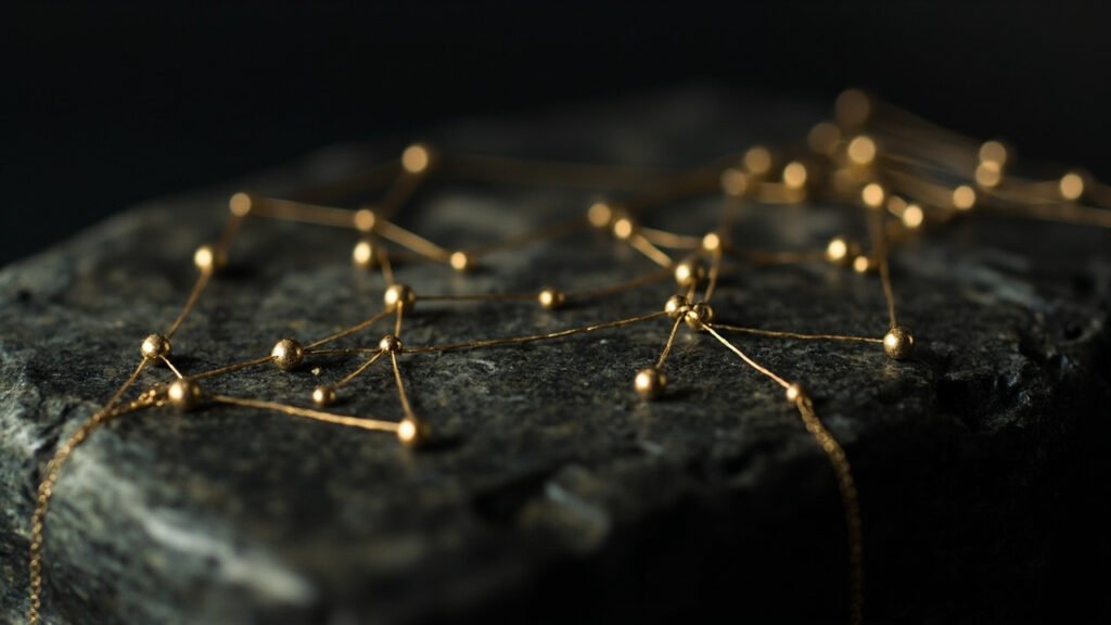 Filaments d'or formant un réseau de traçabilité sur fond sombre.