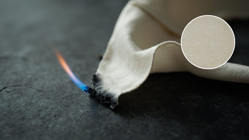 Flamme bleue carbonisant un coin de satin duchesse.