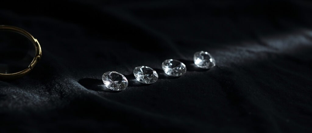 Gemmes taillées en brillant, loupe de bijoutier et velours noir profond.