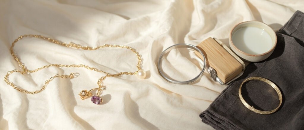Pendentif en or, perle solitaire et bracelet argent sur velours charbon.