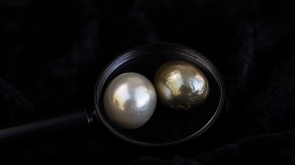 Perle authentique et fausse perle comparées sous loupe