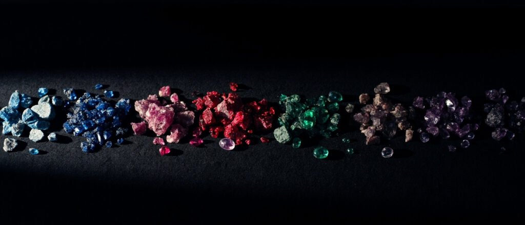 Pierres précieuses et fines étalées sur velours noir, brutes et taillées.