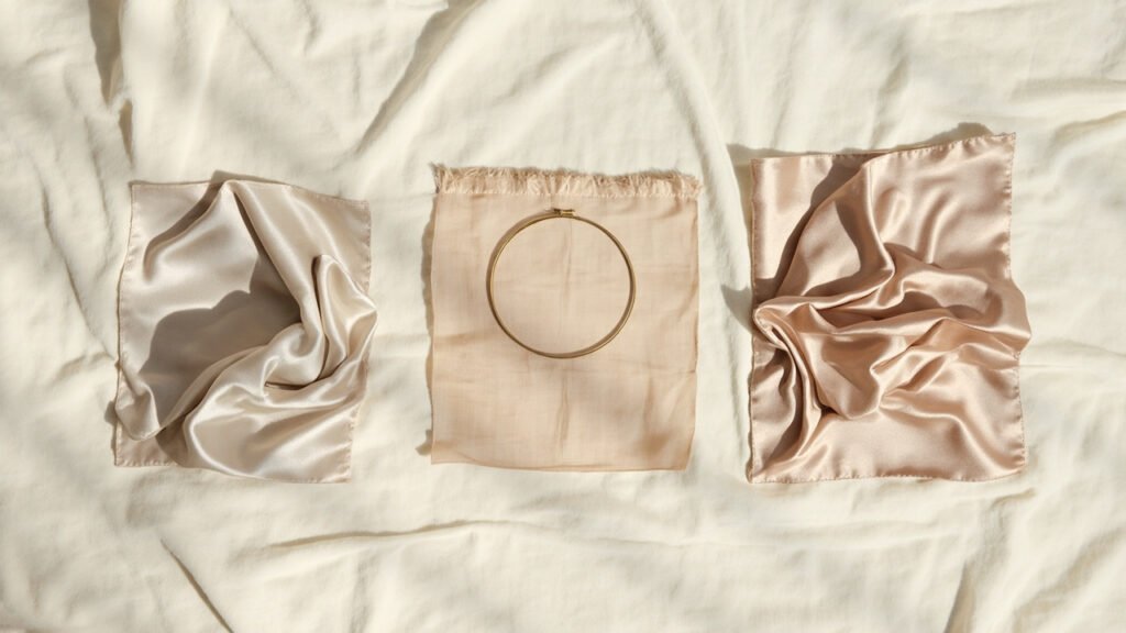Trois carrés de soie testés : drapé, tension, froissement.
