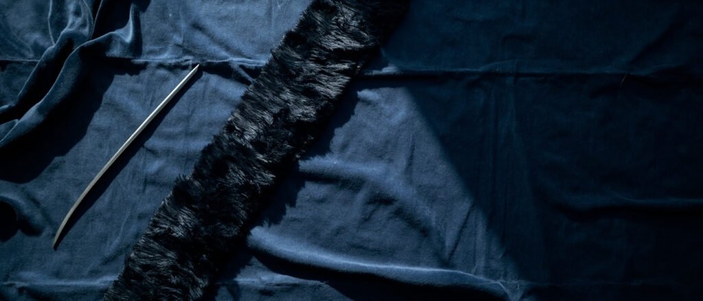 Velours bleu nuit somptueux, sabre d'acier, zones coupées contrastant la peluche.