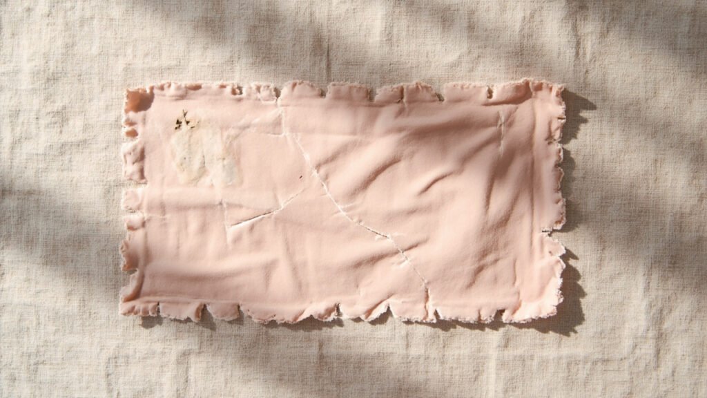 Velours rose marqué par écrasement, usure et boulochage.