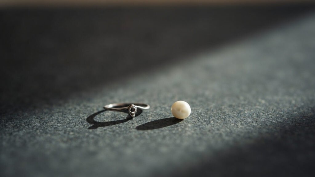 Bague en platine et perle Akoya posée sur ardoise.