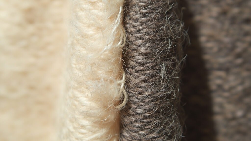Comparaison macro : surface duveteuse du cachemire non teint versus lisse teint