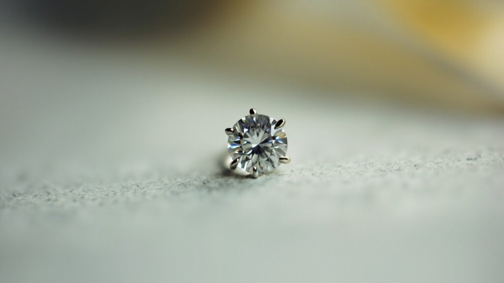 Diamant taille brillant maintenu par quatre griffes métalliques rabattues