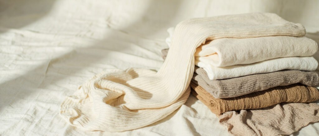 Disposition panoramique de cinq jerseys textiles aux textures naturelles distinctes.