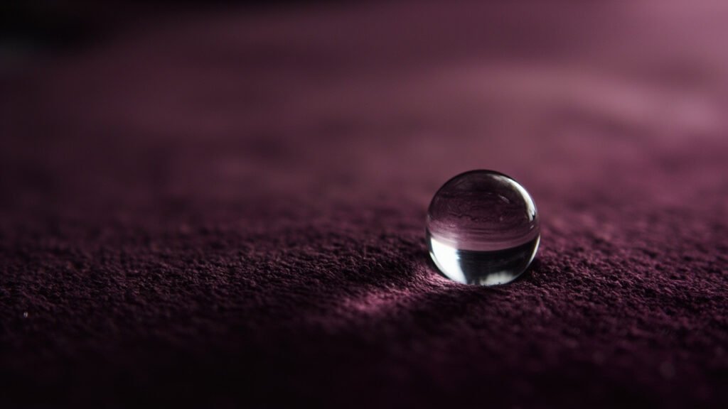 Goutte d'eau perlant sur velours traité hydrophobe