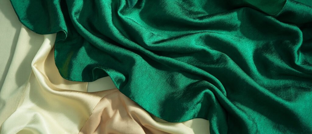 Pli de doupion de soie émeraude, satin champagne et shantung ivoire.