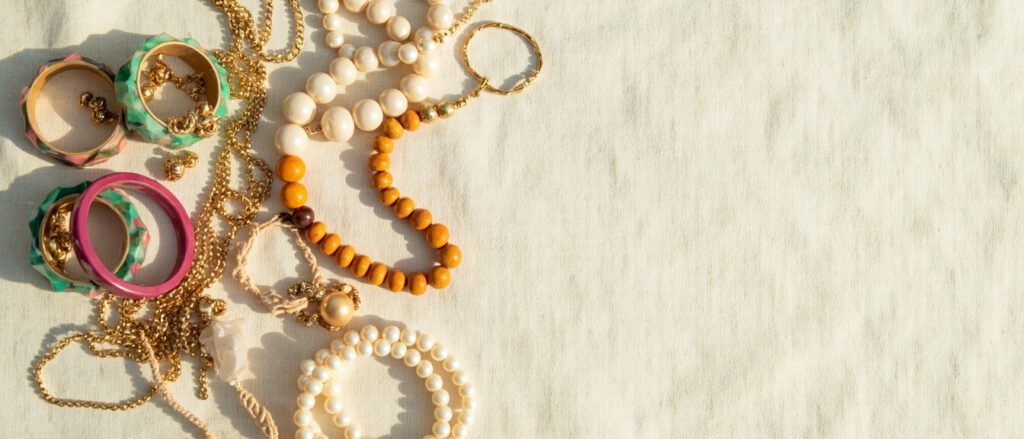 Vue panoramique : bijoux fantaisie et alternatives naturelles sur lin crème.