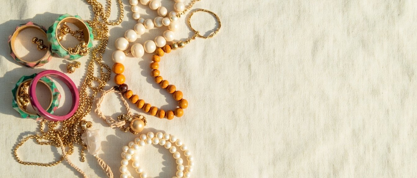 Vue panoramique : bijoux fantaisie et alternatives naturelles sur lin crème.